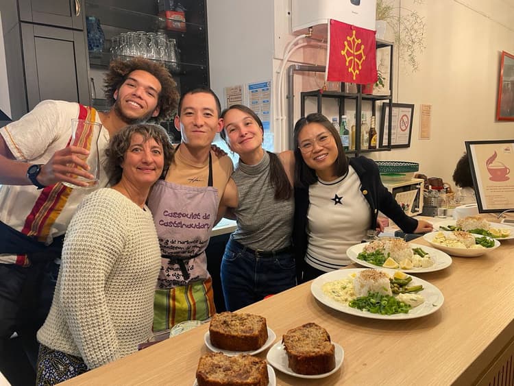 L'équipe du Café d'Oc au comptoir avec des plats faits maison et le drapeau occitan